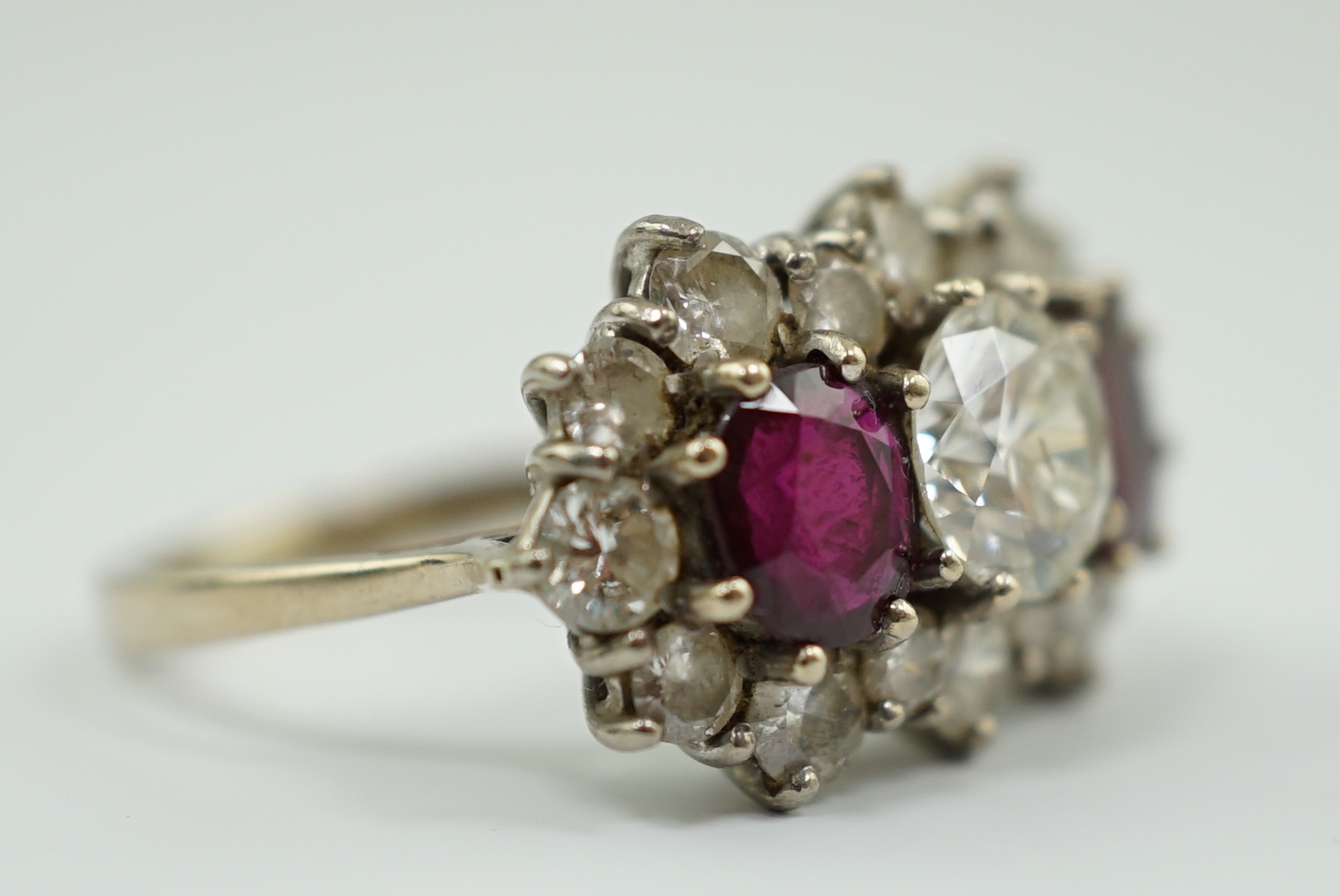 A 1970's 18ct white gold, ruby and diamond set triple cluster dress ring